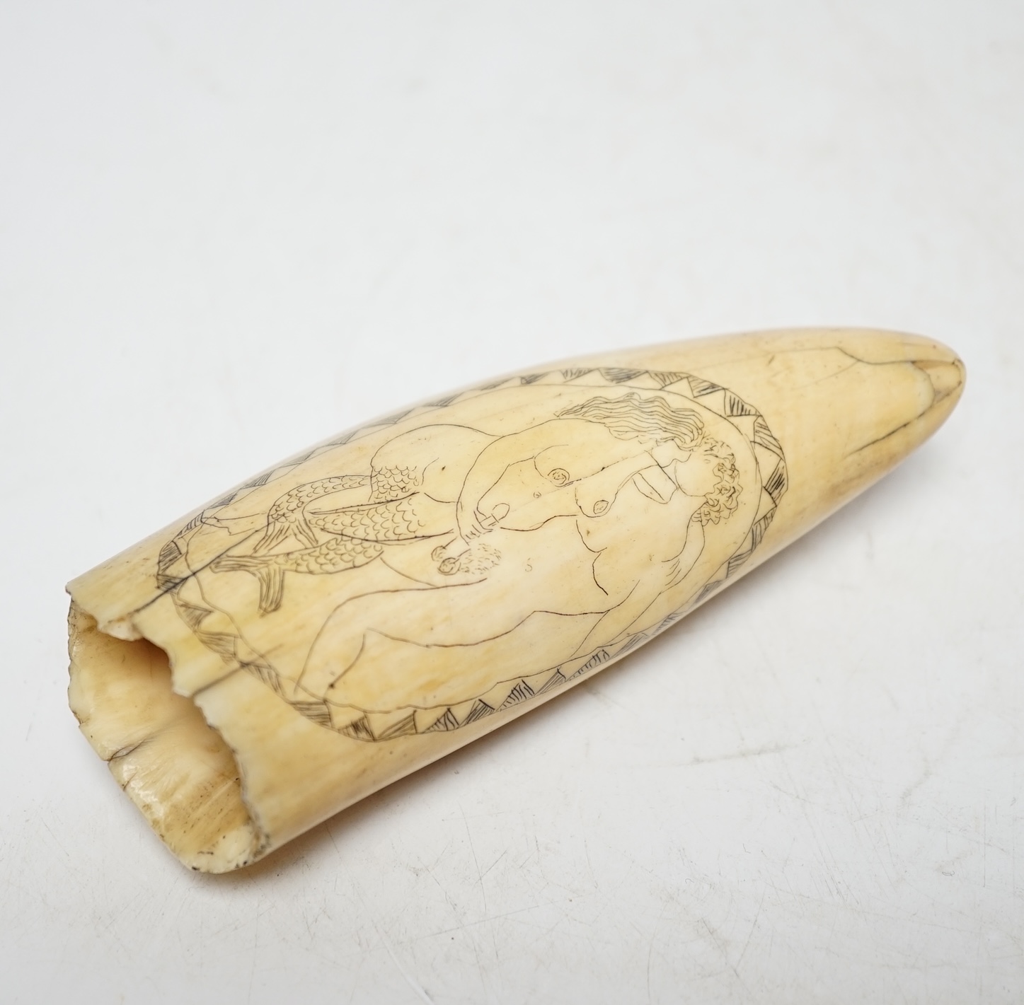 A 19th century scrimshaw erotic carved whale tooth, 13cm in length